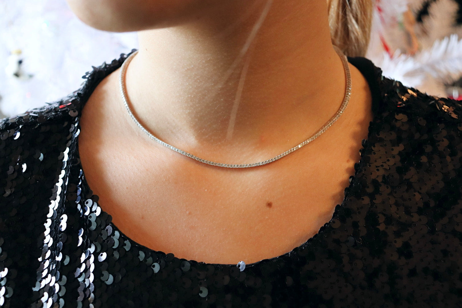 Silver necklace on model in black sequin top